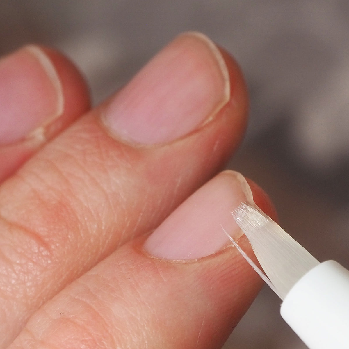 Fingerspitzen die mit einem weißen Pinsel eingestrichen werden